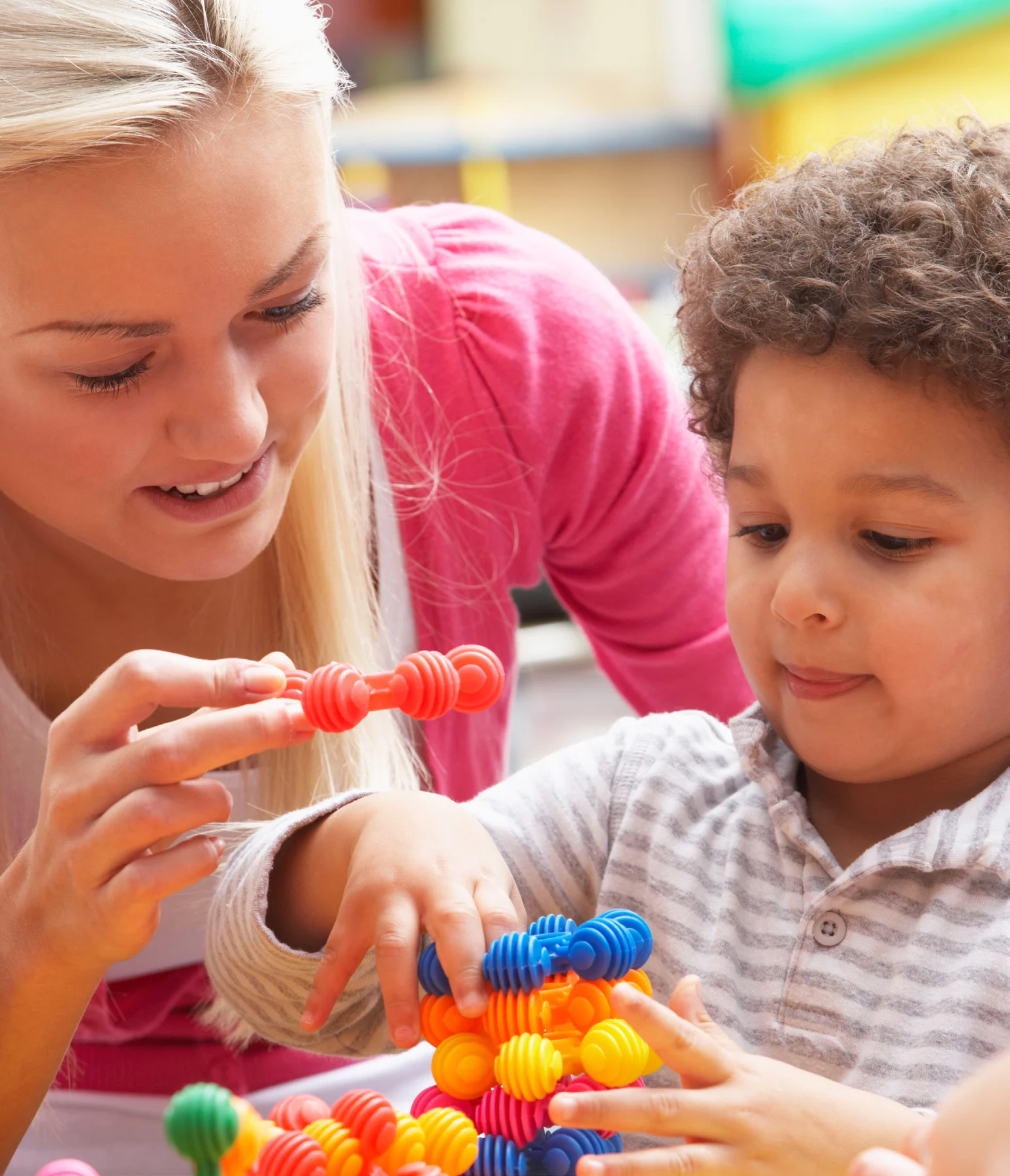 An adult supporting a child's hands-on exploration